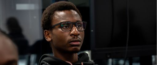 Male student in lecture theatre listening to academic