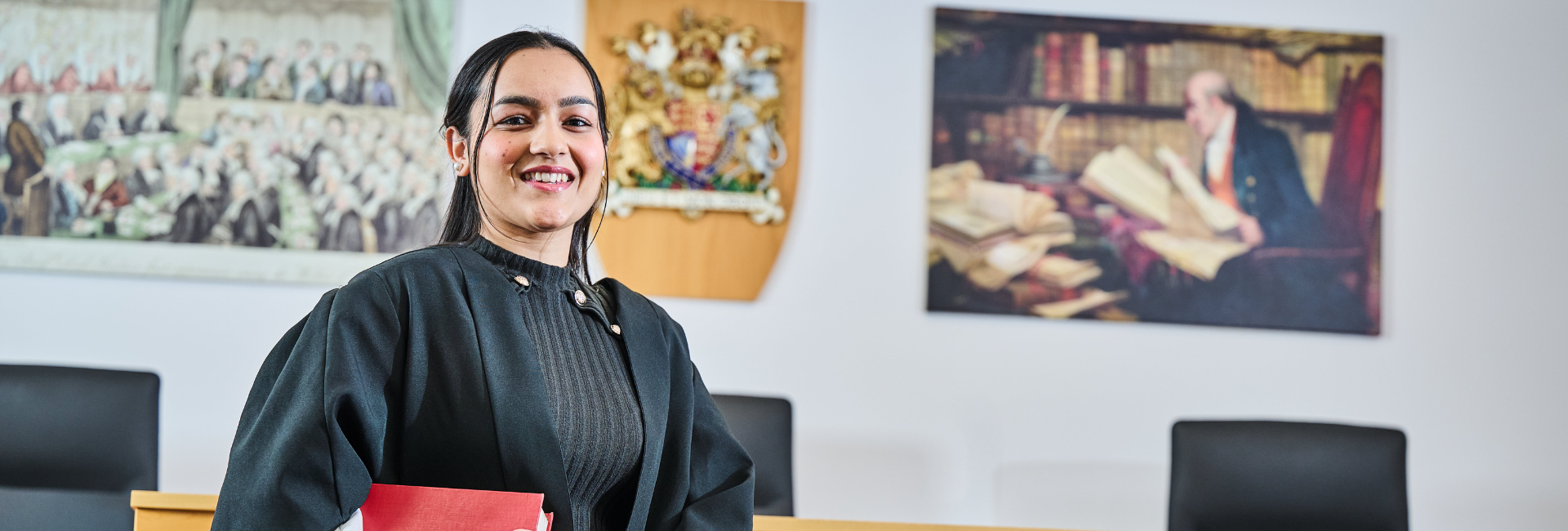 a student in legal robes in a mock court room