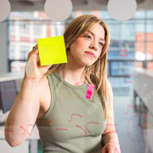 Girl standing at glass screen with a post-it note