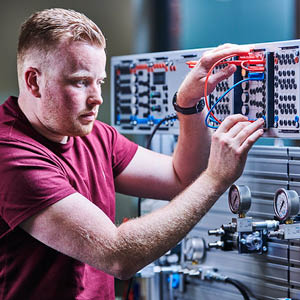 Student working with cables plugged into board.