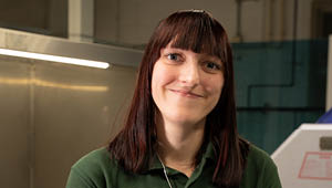 Student standing in front of engineering work bench.