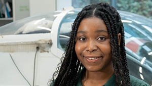 student standing in front of aeroplane in engineering workshop