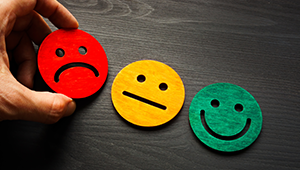 Different wooden blocks of happy and unhappy faces