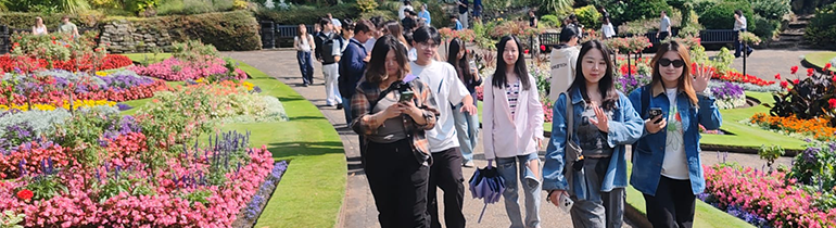 Students walking through an english public gardens in the summer