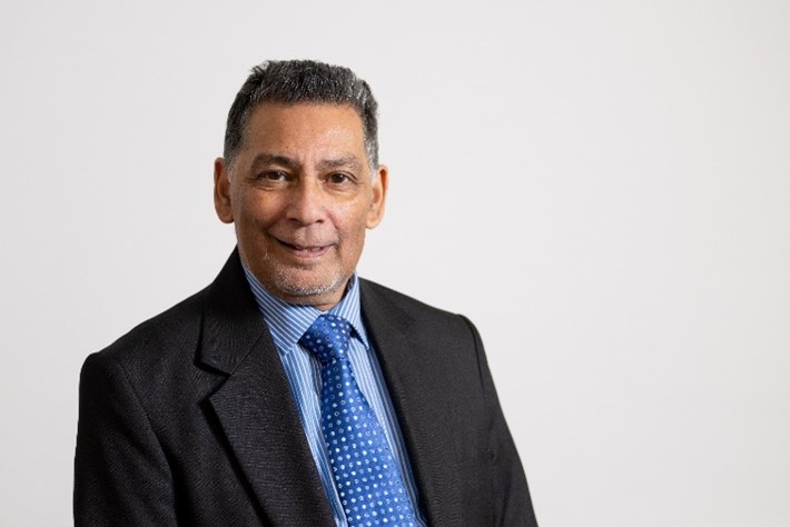 Dr Mashuq Ally, independent governor 2024, wearing a suit and blue shirt against a white background.