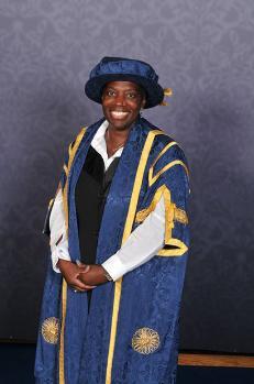 Photograph of Sandra Wallace wearing blue graduation robes.