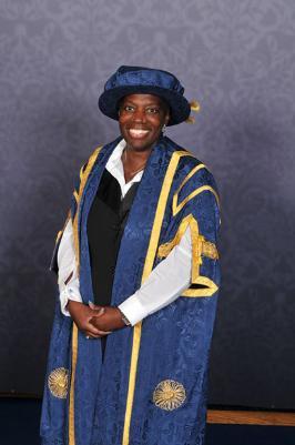 Photograph of Sandra Wallace wearing blue graduation robes.