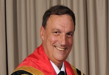 Photograph of Stewart Towe wearing academic robes.