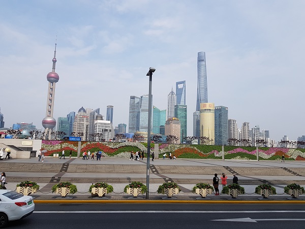 A landscape picture of Shanghai with tall buildings in the background and a garden in the foreground