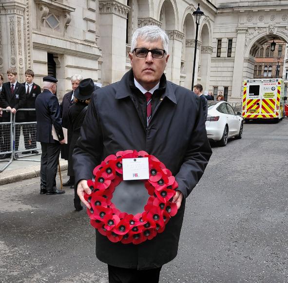An image of Alex Alexandrou holding a wreath of poppies