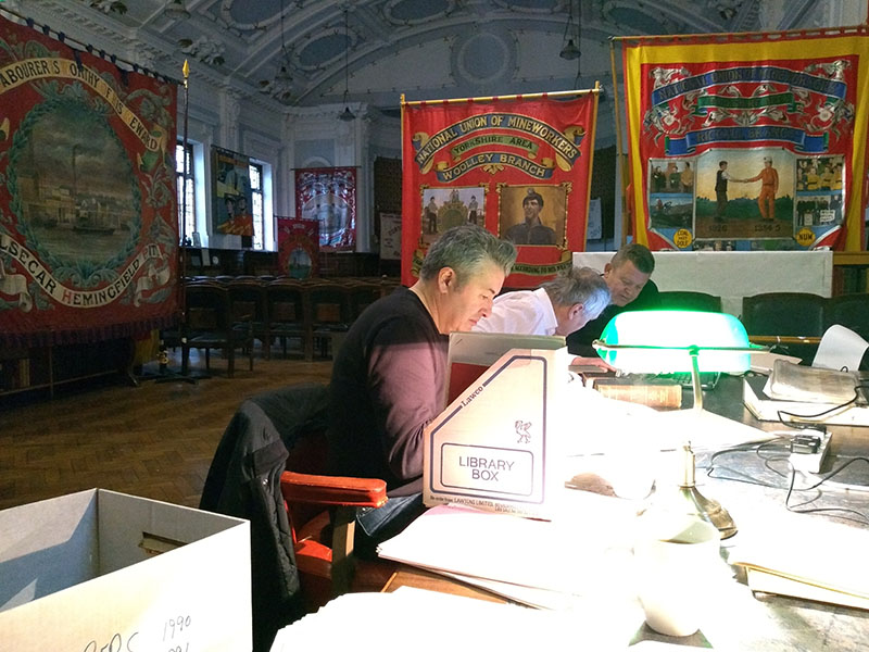 Researchers working in the NUM great all with papers in the foreground and banners in the background