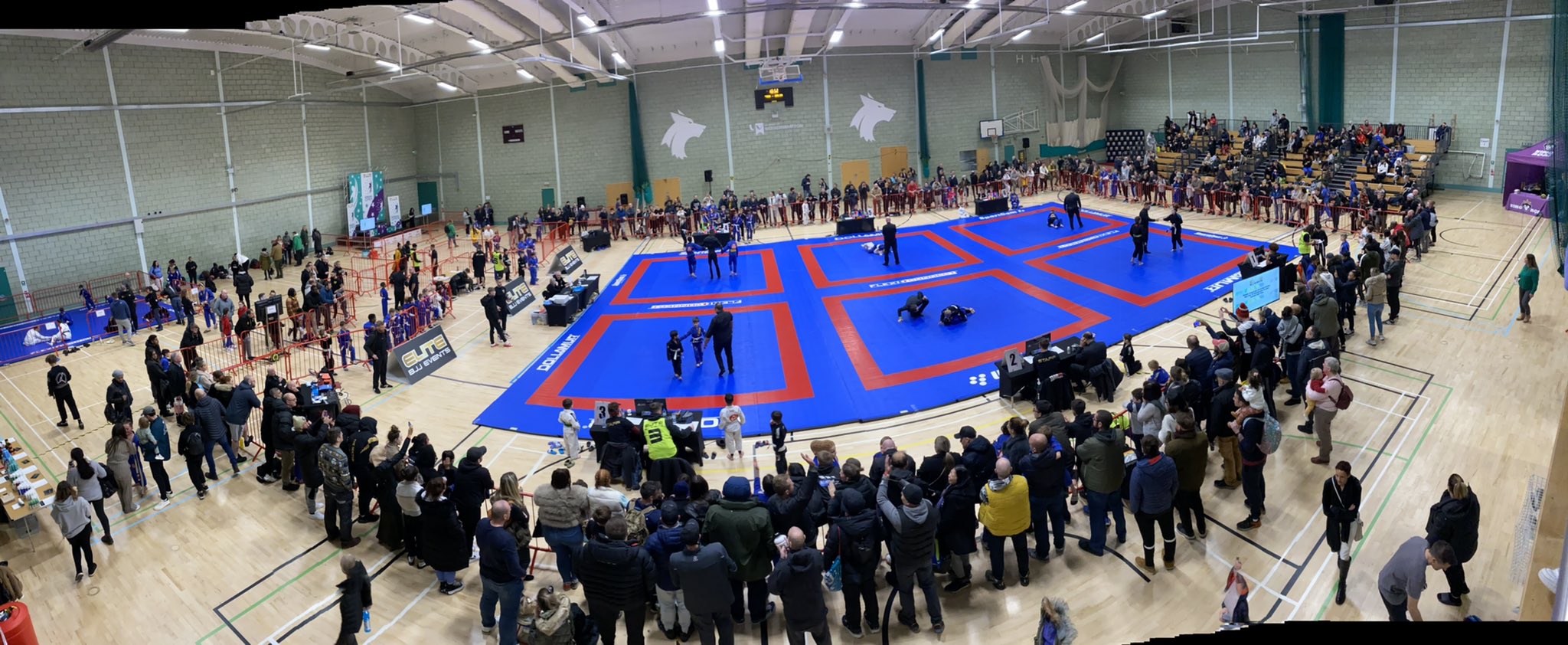 Brazilian Jitsu arenas prepared in the University sports hall, crowded around by onlookers