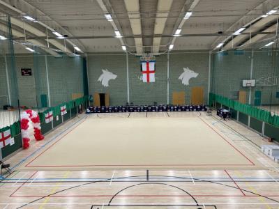 Gymnastics space prepared in the University sports hall, overseen by rows of seats