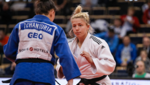 Two judo practitioners facing off, wearing white and blue judogi