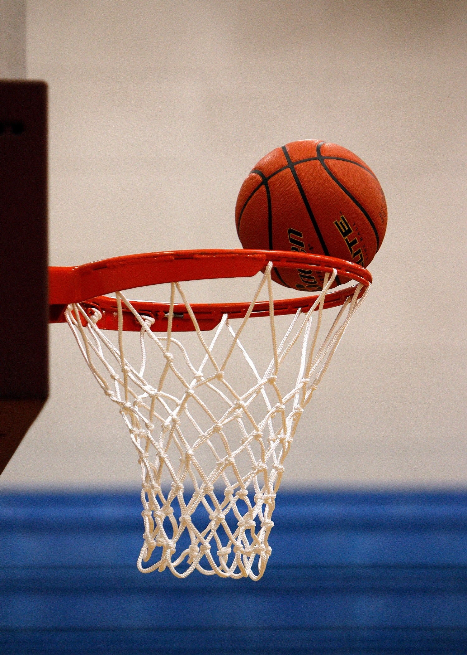 A basketball hoop, the ball thrown to the rim of the hoop and about to go in