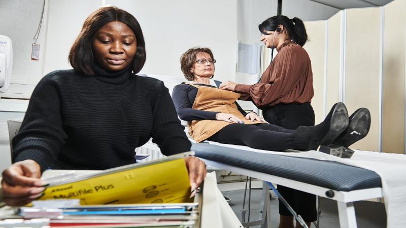 Students working in a School of Pharmacy practice room, looking at documents and simulating real practice