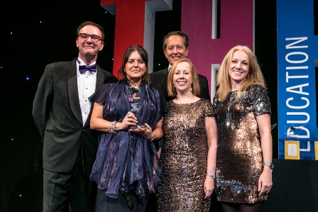 Clare Dickens at the 2016 Times Higher Education Awards, being crowded around and holding an award